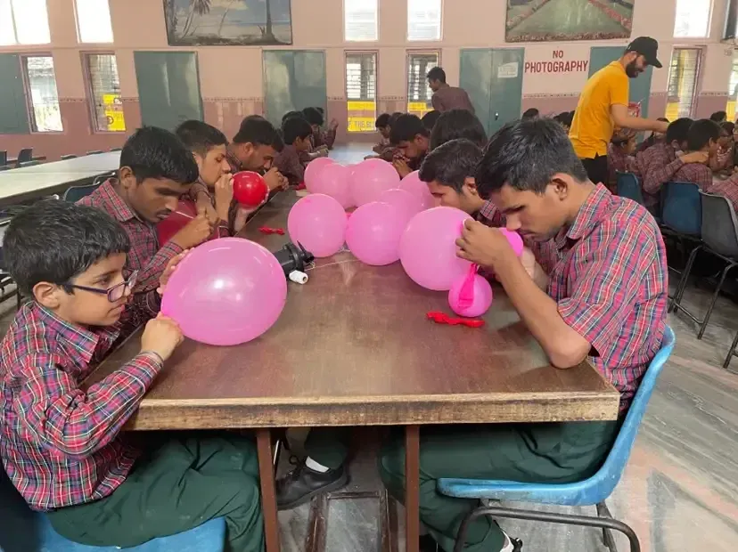 students blowing balloons